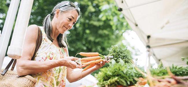 mujer mayor sosteniendo verduras