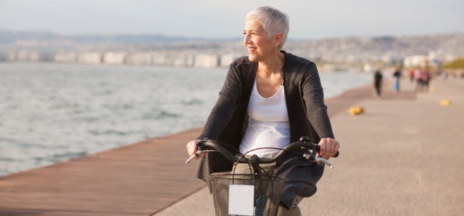Incluir los ejercicios cardiovasculares a tu rutina diaria Mujer dando un paseo en bicicleta como unos de los ejercicios cardiovasculares