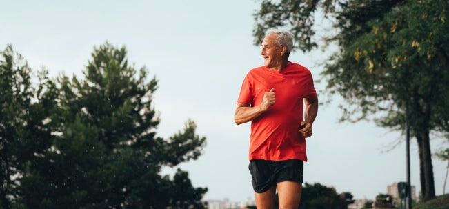 Importancia de los ejercicios cardiovasculares Hombre mayor de 50 años trotando por un parque