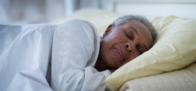 Mujer mayor de 50 años durmiendo en su cama