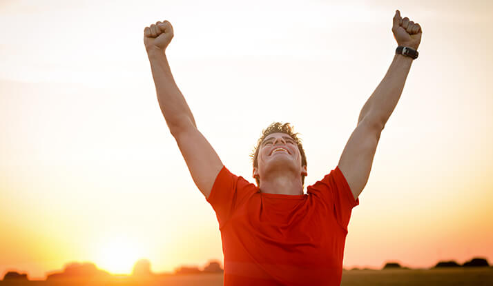 Hombre descubre que es vitalidad con brazos levantados feliz